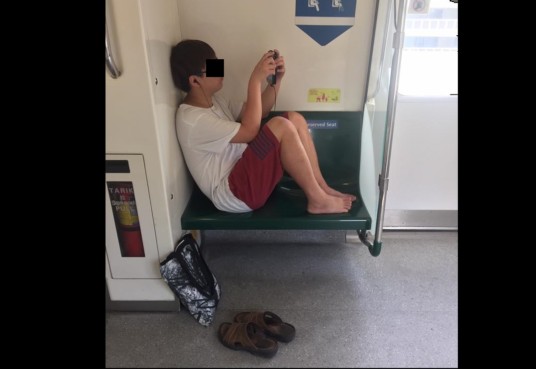 GUY THINKS THE MRT IS HIS HOUSE SIA. PUT LEG ON RESERVED SEAT.
