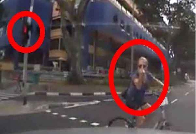 GANGSTER CYCLIST FLICKS THE FINGER AT DRIVER WHILE CROSSING DURING RED LIGHT(VIDEO)