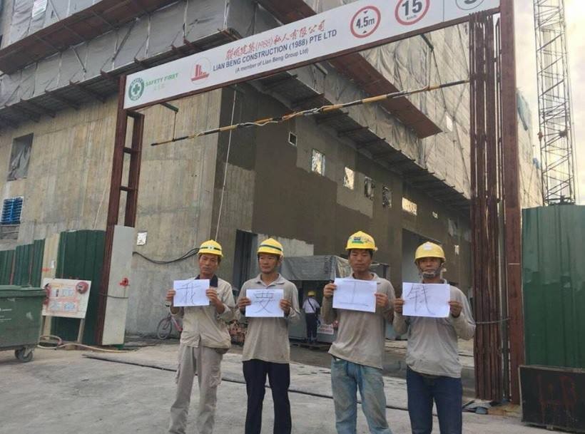 FOREIGN WORKERS HOLD SIGNS. DEMAND FOR SALARY