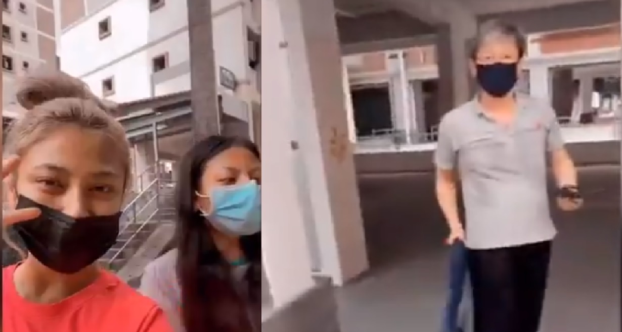 UNCLE THREATENS SISTERS WHO ARE SMOKING AT VOID DECK WITH UMBRELLA