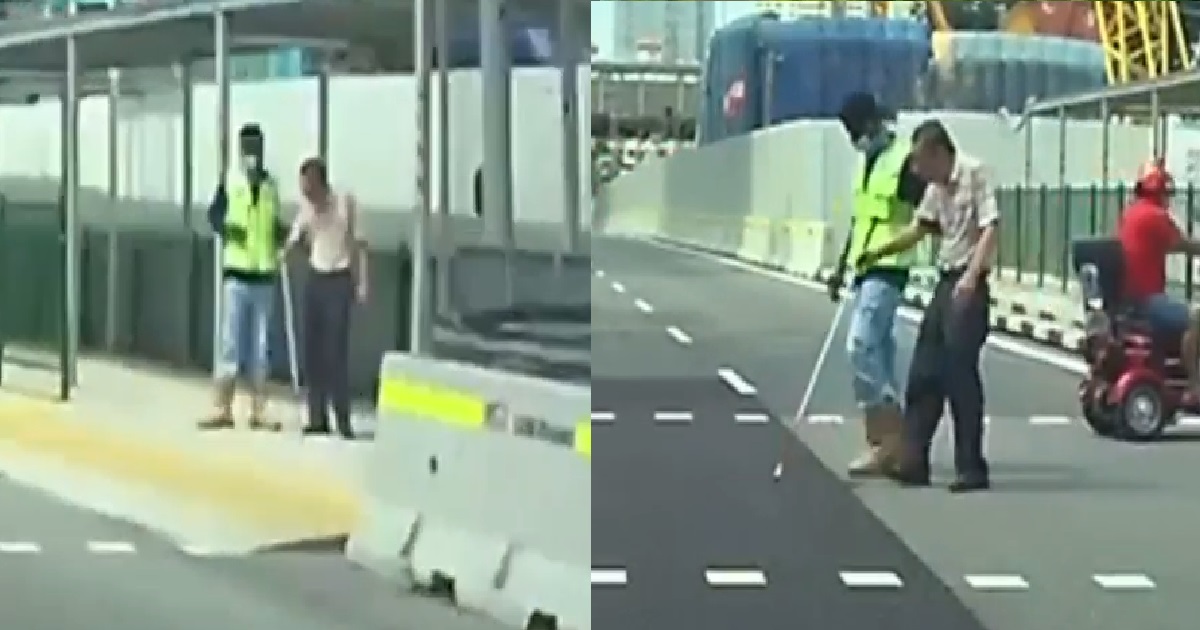 INDIAN WORKER HELPS FRAIL ELDERLY MAN TO CROSS THE ROAD