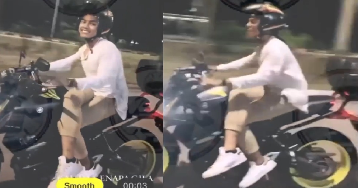 MOTORCYCLIST RIDING ON ROAD WITH HIS LEGS CROSSED BECAUSE YOLO