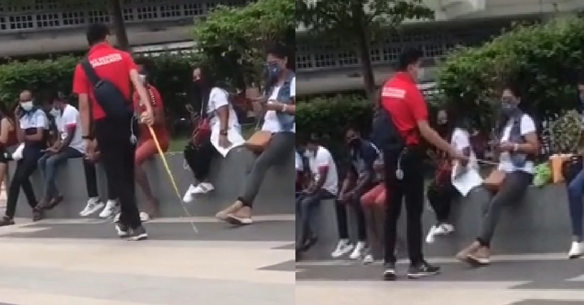 SAFE DISTANCING AMBASSADOR USE MEASURING TAPE TO CHECK SOCIAL DISTANCING