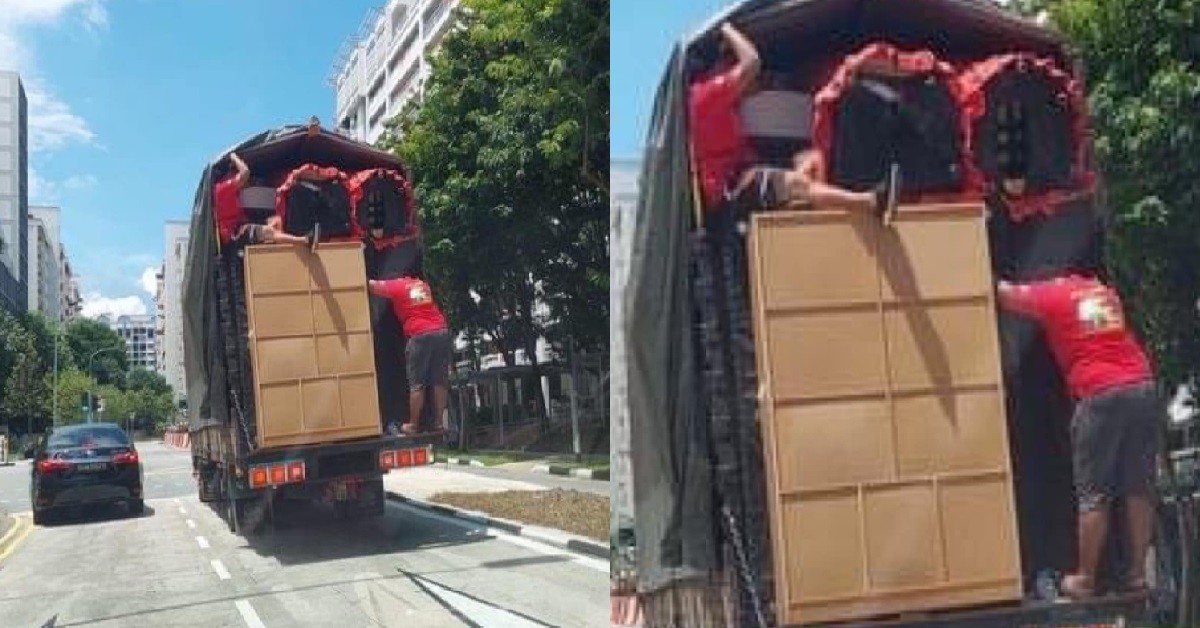 WORKERS STAND DANGEROUSLY AT BACK OF LORRY TO HOLD GOODS IN PLACE
