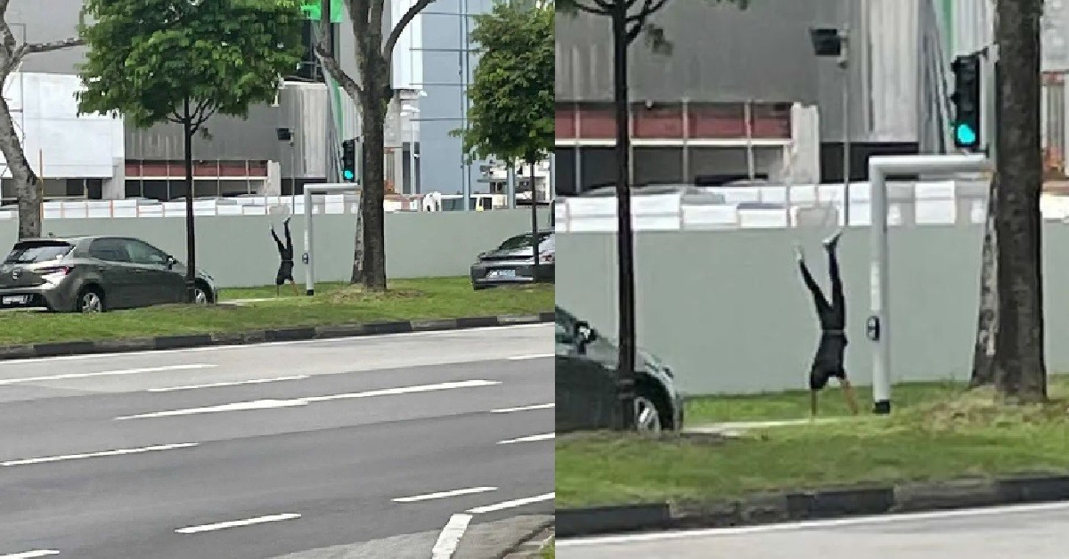 MAN DOING HAND STAND WHILE WAITING FOR TRAFFIC LIGHT TO TURN GREEN