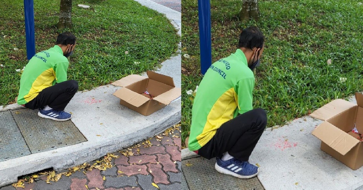 POOR CLEANER SCRAPING CANDLE WAX FROM HUNGRY GHOST MONTH OFFERINGS