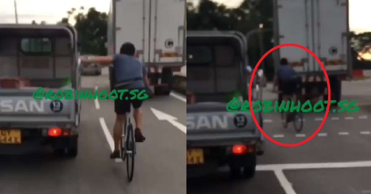 CRAZY CYCLIST HOLD ON TO LORRY ON ROAD, RIDING IN BETWEEN LORRIES