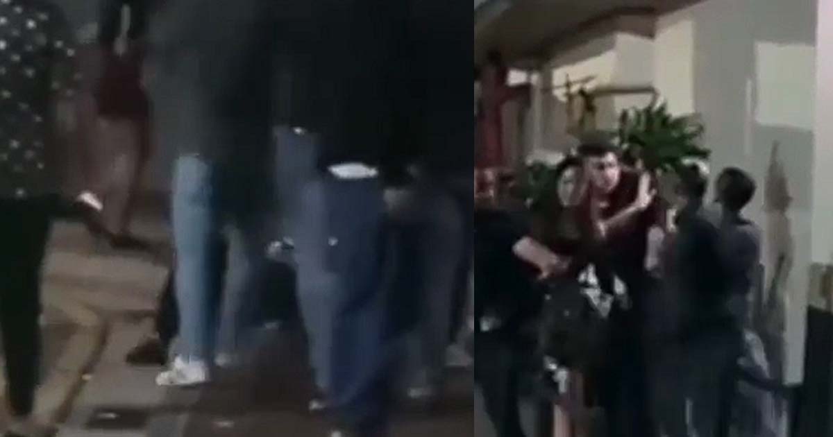 LARGE GROUP OF MEN FIGHTING OUTSIDE A DRINKING JOINT ALONG BEACH ROAD