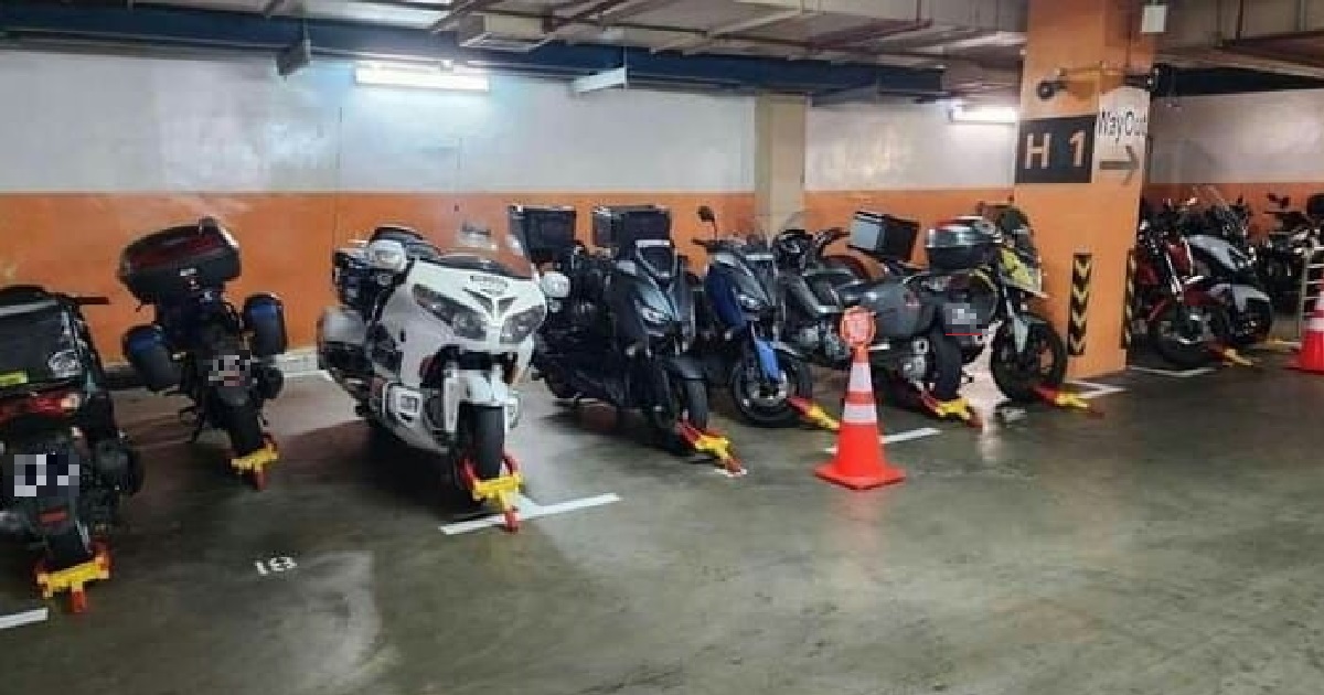 WHOLE ROW OF MOTORCYCLES KENA WHEEL CLAMPED FOR PARKING IN LOT FOR CARS @ NUH