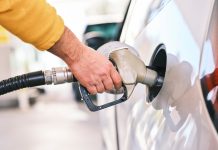 a man pumping gas into his car at a gas station